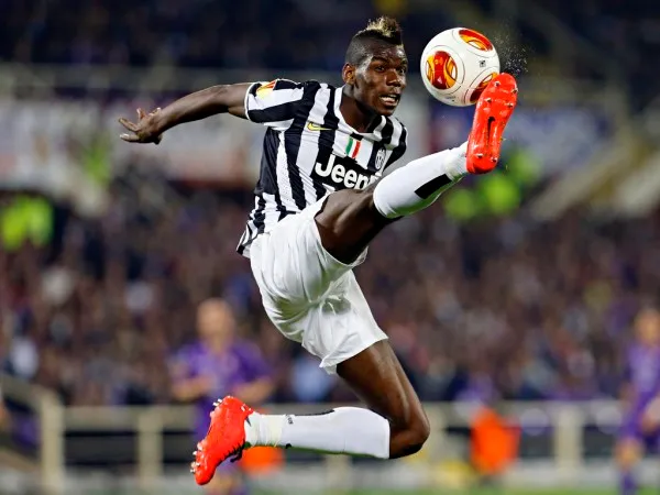 Juventus' Paul Pogba is airborne as he jumps to control the ball