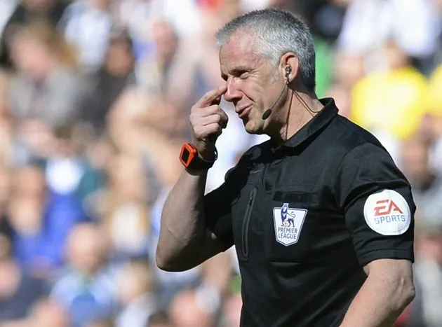 Referee Foy reacts after being hit in the face by a football during the English Premier League soccer match between Newcastle United and Swansea City at St James' Park in Newcastle