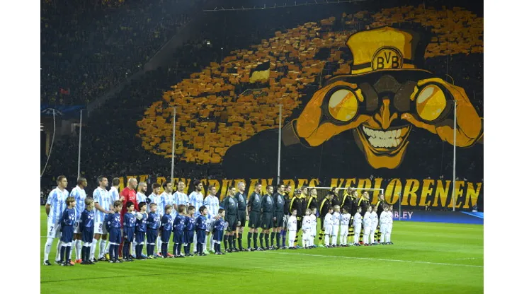 Dortmund's fans wave with yellow colours as the team pose for a family picture before the UEFA Champions League quarter-final second-leg football match Borussia Dortmund vs Malaga CF in Dortmund, western Germany on April 9, 2013. AFP PHOTO / ODD ANDERSEN (Photo credit should read ODD ANDERSEN/AFP/Getty Images)