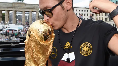 BERLIN, GERMANY - JULY 15: Mesut Oezil celebrates on the open top bus at the German team victory ceremony on July 15, 2014 in Berlin, Germany. Germany won the 2014 FIFA World Cup Brazil match against Argentina in Rio de Janeiro on July 13. (Photo by Markus Gilliar - Pool/Getty Images)