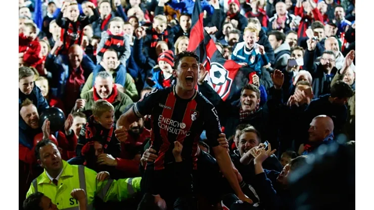 BOURNEMOUTH, ENGLAND – APRIL 27: Captain Tommy Elphick of Bournemouth celebrates victory as fans invade the pitch after the Sky Bet Championship match between AFC Bournemouth and Bolton Wanderers at Goldsands Stadium on April 27, 2015 in Bournemouth, England. (Photo by Clive Rose/Getty Images)