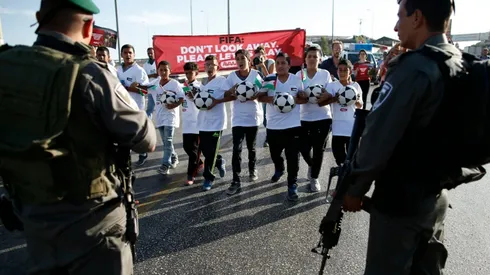 Palestinian youths march on settlement in message to FIFA