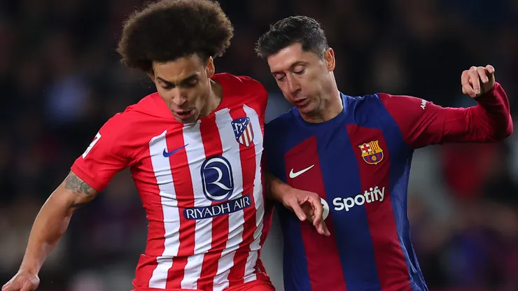 Robert Lewandowski of FC Barcelona challenges for the ball with Axel Witsel of Atletico Madrid during the LaLiga EA Sports match between FC Barcelona and Atletico Madrid at Estadi Olimpic Lluis Companys on December 03, 2023 in Barcelona, Spain.
