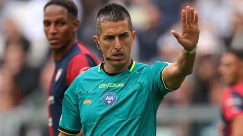 Referee Livio Marinelli holds up play as a VAR check takes place for a possible penalty during the Serie A match between Juventus FC and Cagliari Calcio at Allianz Stadium on October 06, 2024 in Turin, Italy.