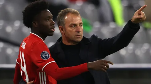Hans-Dieter Flick, head coach of FC Bayern München talks to his player Alphonso Davies during the UEFA Champions League Group A stage match between FC Bayern Muenchen and Atletico Madrid at Allianz Arena on October 21, 2020 in Munich, Germany.