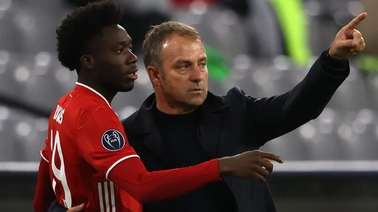Hans-Dieter Flick, head coach of FC Bayern München talks to his player Alphonso Davies during the UEFA Champions League Group A stage match between FC Bayern Muenchen and Atletico Madrid at Allianz Arena on October 21, 2020 in Munich, Germany.