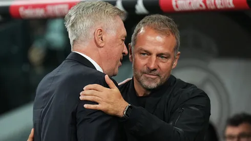 Hansi Flick, Head Coach of FC Barcelona, interacts with Carlo Ancelotti, Head Coach of Real Madrid, prior to the LaLiga match between Real Madrid CF and FC Barcelona at Estadio Santiago Bernabeu on October 26, 2024 in Madrid, Spain.