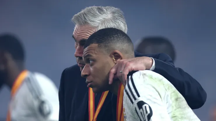 Carlo Ancelotti, Head Coach of Real Madrid, embraces Kylian Mbappe of Real Madrid during the trophy presentation after the Spanish Super Cup Final between Real Madrid and FC Barcelona at King Abdullah Sports City on January 12, 2025 in Jeddah, Saudi Arabia.