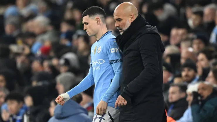 Manchester City coach Pep Guardiola speaking to Phil Foden.
