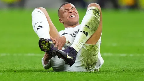 Kylian Mbappe of Real Madrid lays on the pitch holding his ankle during the UEFA Champions League 2024/25 Quarter Final Second Leg match between Real Madrid C.F. and Arsenal FC at Estadio Santiago Bernabeu on April 16, 2025 in Madrid, Spain.