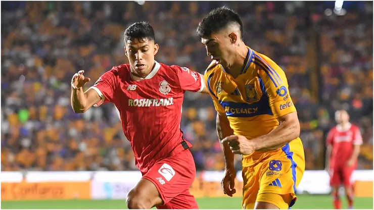 Juan Brunetta of Tigres fights for the ball with Diego Barbosa of Toluca