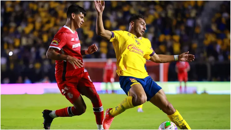 Robert Morales of Toluca battles for possession with Sebastian Caceres of America