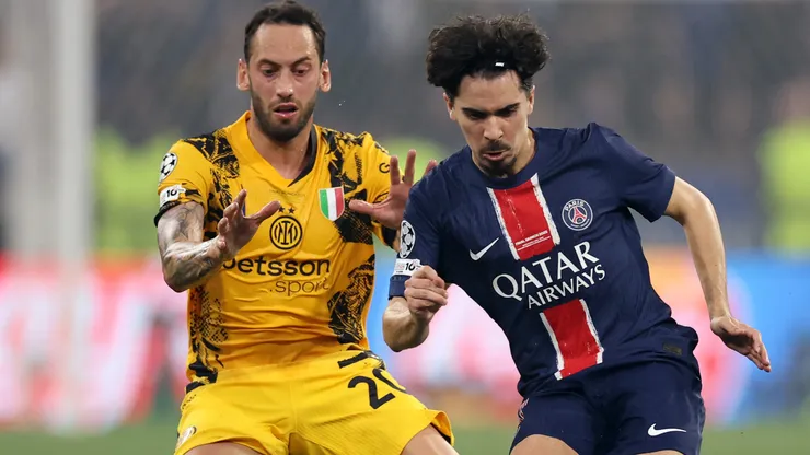 Vitinha of Paris Saint-Germain passes the ball whilst under pressure from Hakan Calhanoglu of FC Internazionale during the UEFA Champions League Final 2025 between Paris Saint-Germain and FC Internazionale Milano at Munich Football Arena on May 31, 2025 in Munich, Germany.