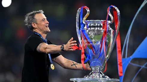 Wearing a shirt with the Xana Foundation logo, Luis Enrique knelt on the field next to a PSG flag.