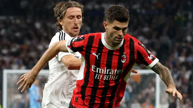 Christian Pulisic of AC Milan runs with the ball whilst under pressure from Luka Modric of Real Madrid during the UEFA Champions League 2024/25 League Phase MD4 match between Real Madrid C.F. and AC Milan at Estadio Santiago Bernabeu on November 05, 2024 in Madrid, Spain.