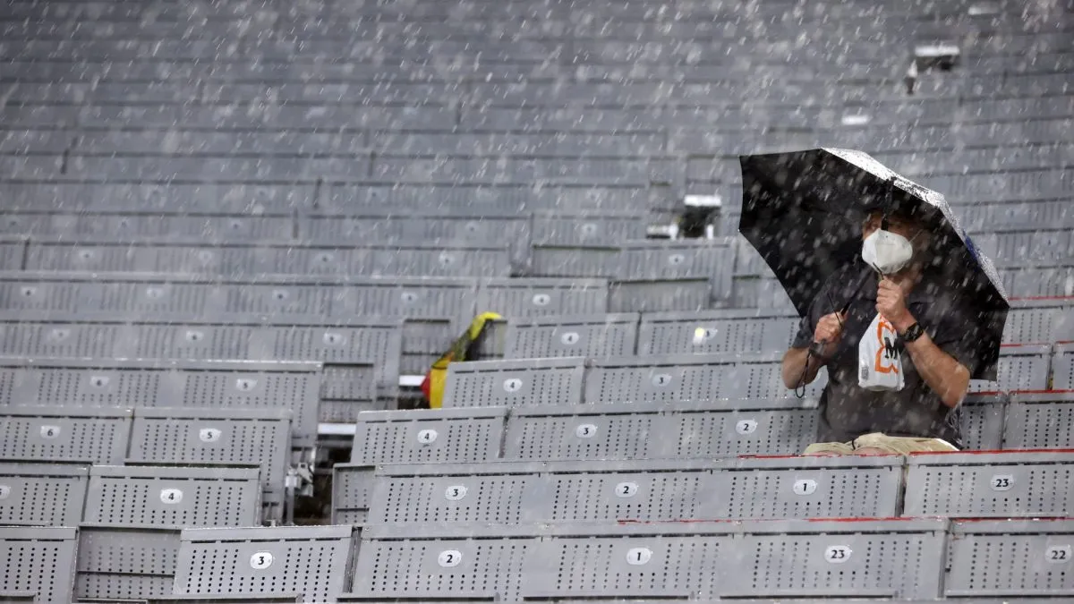 A fan of Germany looks on with an umbrella as rain falls during the UEFA Euro 2020 Championship Group F match between Germany and Hungary at Allianz Arena in 2021. (Source: Alexander Hassenstein/Getty Images)