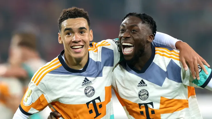 Jamal Musiala of Bayern Munich celebrates scoring their side's fourth goal with teammate Alphonso Davies during the DFB Cup second round match between FC Augsburg and FC Bayern München at WWK-Arena on October 19, 2022 in Augsburg, Germany.