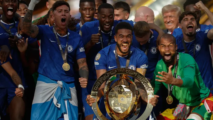 Reece James #24 of Chelsea FC celebrates with the FIFA Club World Cup trophy with Robert Sanchez #1 as U.S. President Donald Trump looks on after the team's victory in the FIFA Club World Cup 2025 Final match between Chelsea FC and Paris Saint-Germain at MetLife Stadium on July 13, 2025 in East Rutherford, New Jersey.