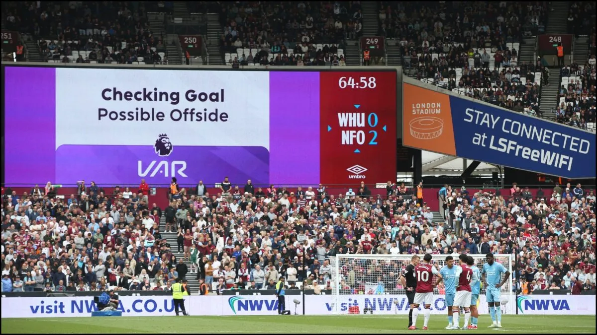 A big screen displays details of a VAR review during a Premier League match.