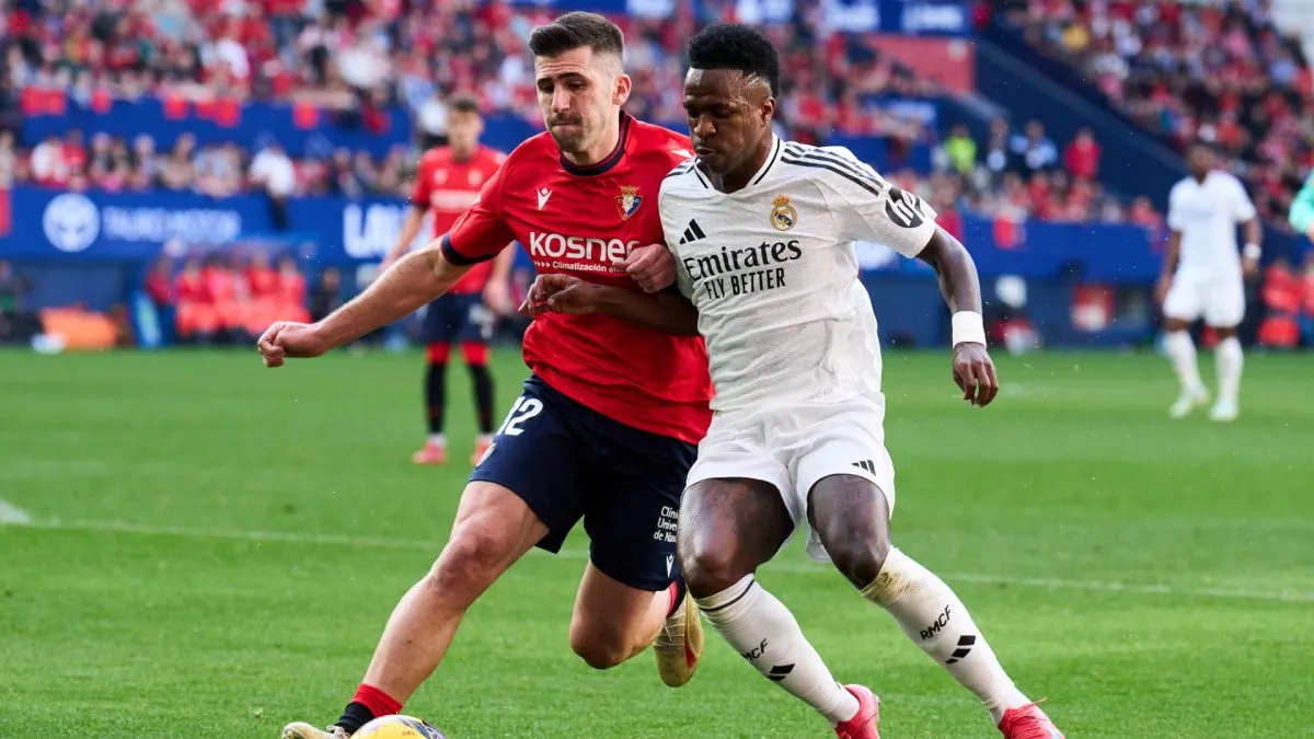 Vinicius Junior of Real Madrid duels for the ball with Jesus Areso of CA Osasuna during the LaLiga match between CA Osasuna and Real Madrid CF at Estadio El Sadar on February 15, 2025 in Pamplona, Spain.
