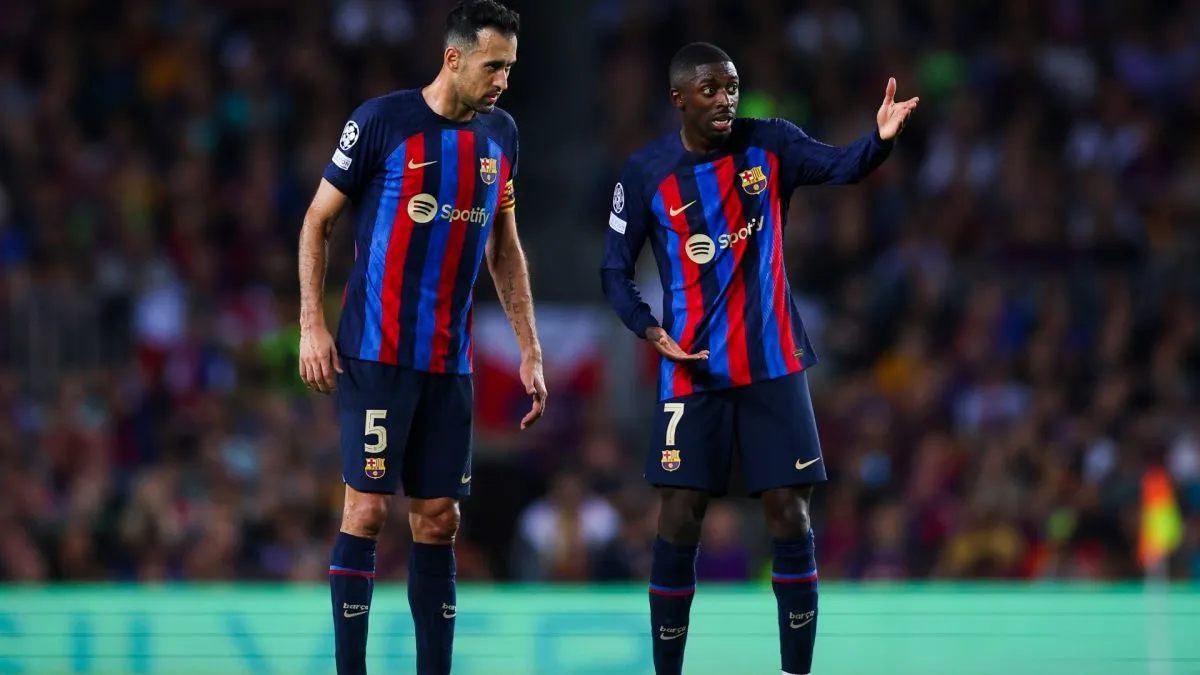 Sergio Busquets and Ousmane Dembele of FC Barcelona speak during a UEFA Champions League match vs Inter Milan on October 12, 2022.