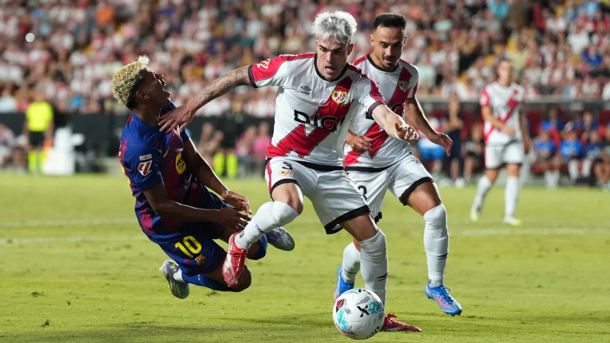 Pep Chavarria of Rayo Vallecano makes contact with Lamine Yamal of FC Barcelona during the LaLiga EA Sports match between Rayo Vallecano de Madrid and FC Barcelona.