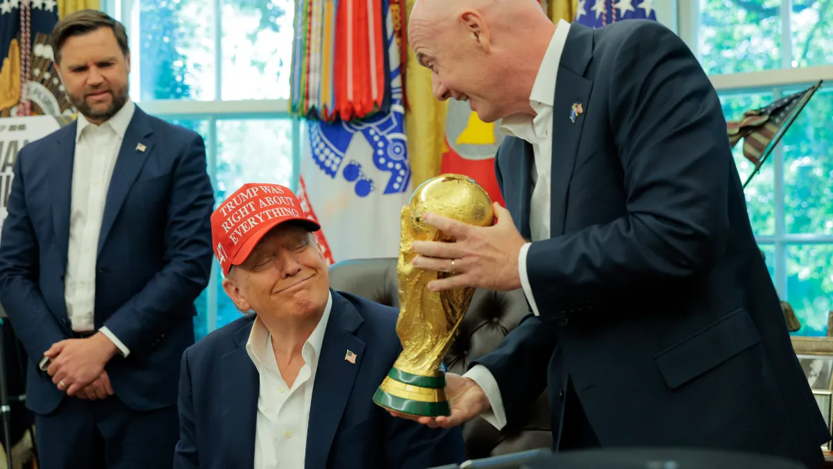 FIFA President Gianni Infantino shows U.S. President Donald Trump the World Cup Trophy in the Oval Office.