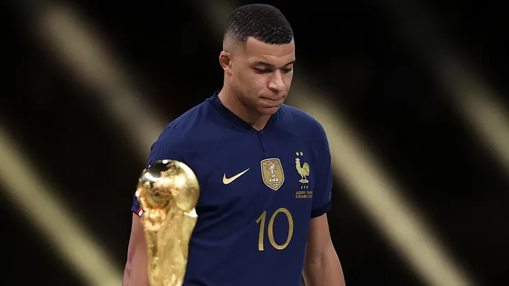 Kylian Mbappe of France walks past the FIFA World Cup trophy as he looks dejected following his team's loss in the final match against Argentina.