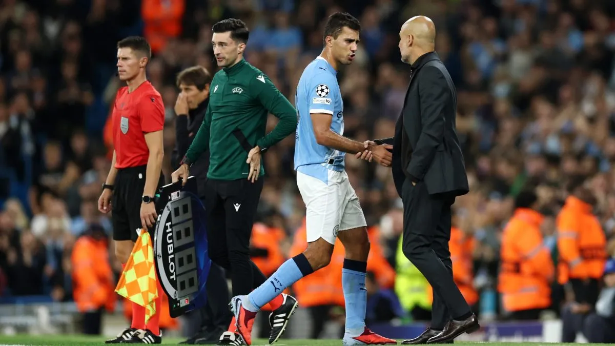 Rodri of Manchester City speaks to Pep Guardiola, Manager of Manchester City, after being substituted.