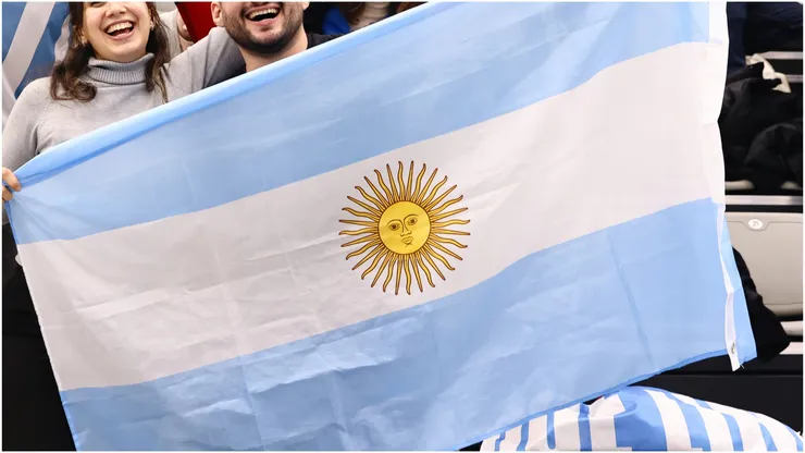 Fans of Argentina pose for a photo with a flag