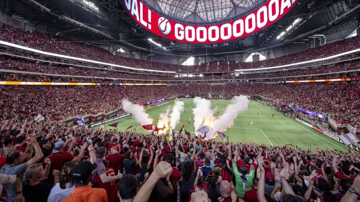 Atlanta United fans celebrating a team's goal at the Mercedes-Benz Stadium.