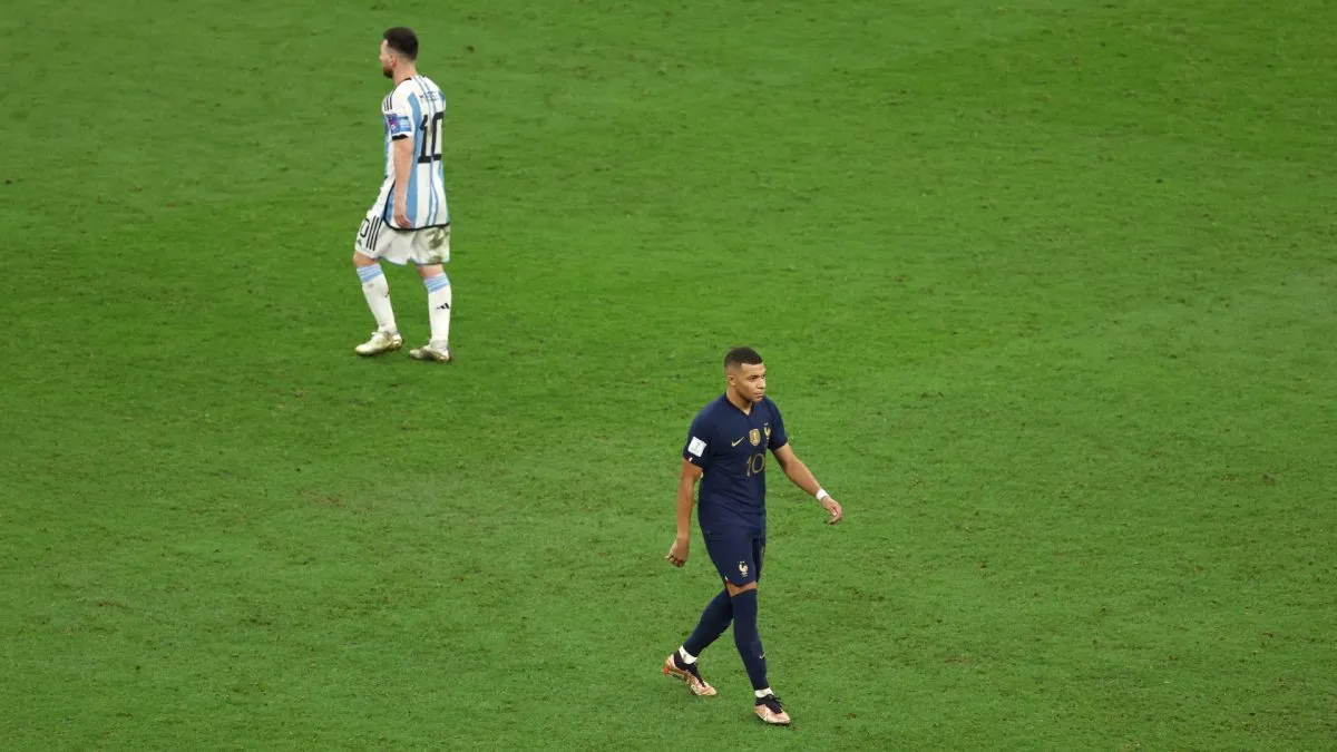Kylian Mbappe of France celebrates scoring the team's first penalty in the penalty shoot out as Lionel Messi of Argentina prepares to take theirs.
