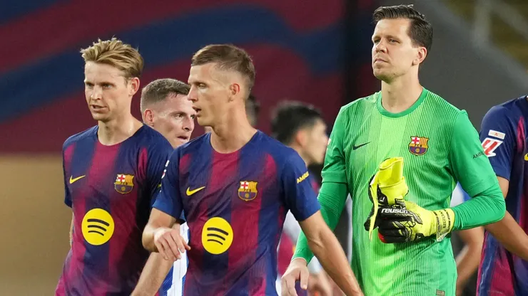 Players of FC Barcelona look on.