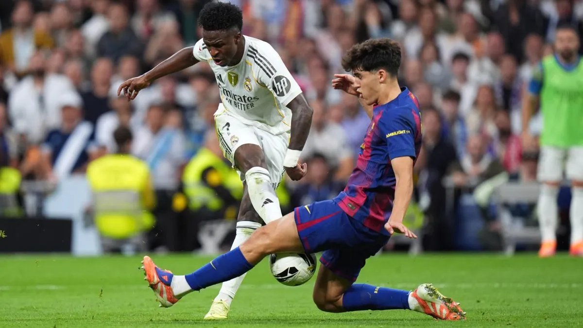 Real Madrid star Vinicius Jr being covered by Pau Cubarsi of Barcelona