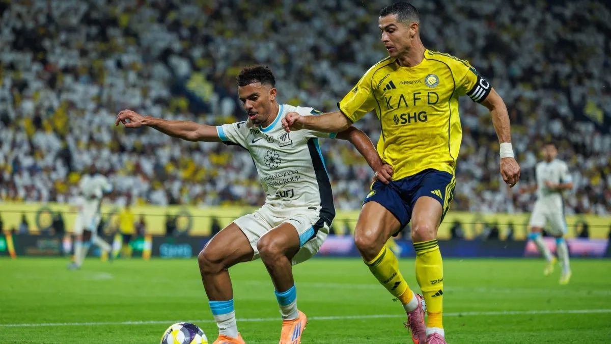 Cristiano Ronaldo of Al-Nassr FC competes for the ball with Ahmed Al-Julaydan of Al-Ittihad FC.