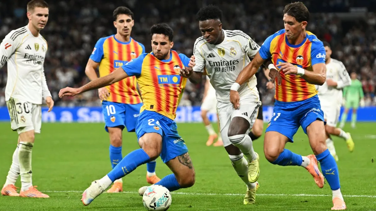 Vinicius Junior fighting for the ball against Valencia players Eray Coemert and Jesus Vazquez 