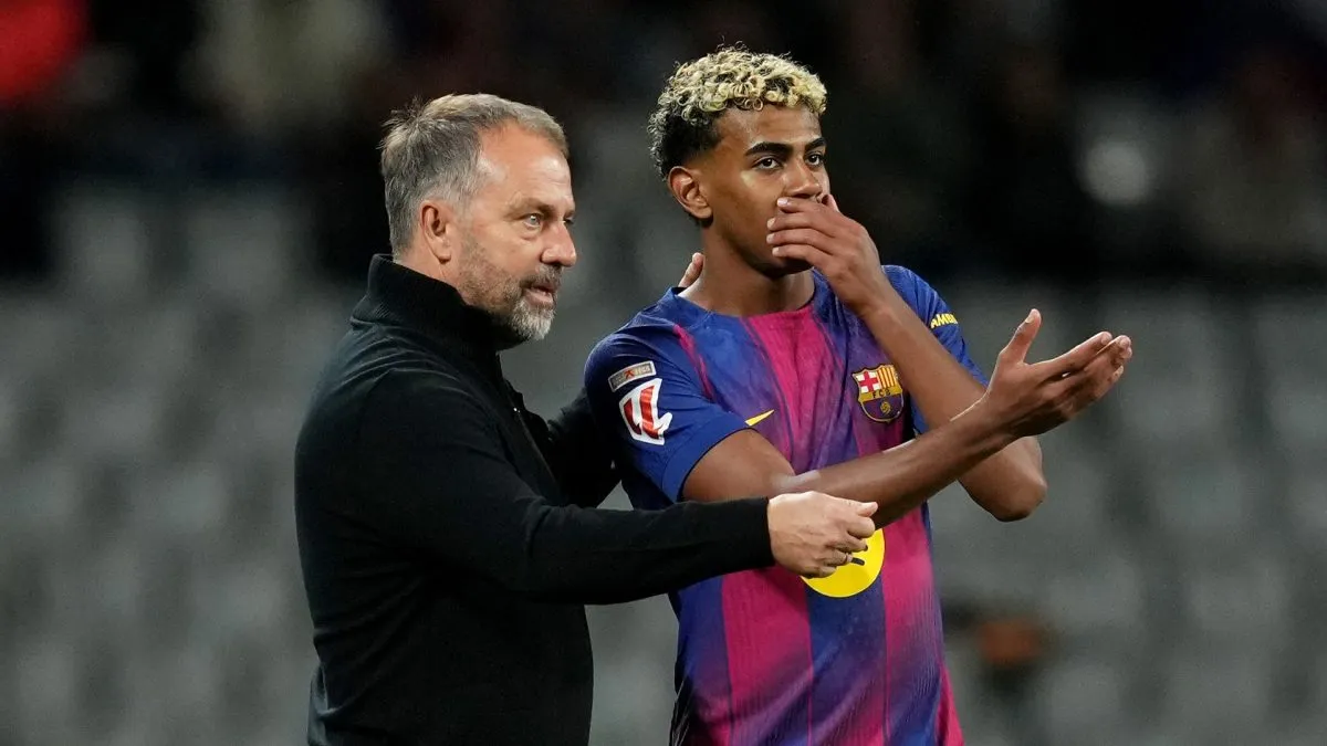 Hansi Flick, Head Coach of FC Barcelona, speaks with Lamine Yamal.