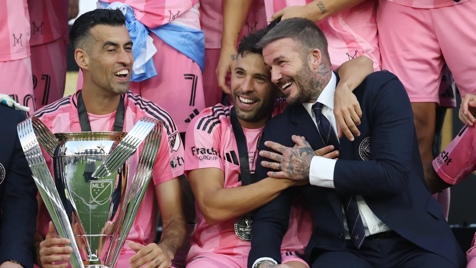 Sergio Busquets #5, Jordi Alba #18 and David Beckham, co-owner of Inter Miami CF, celebrate with the MLS Cup trophy.