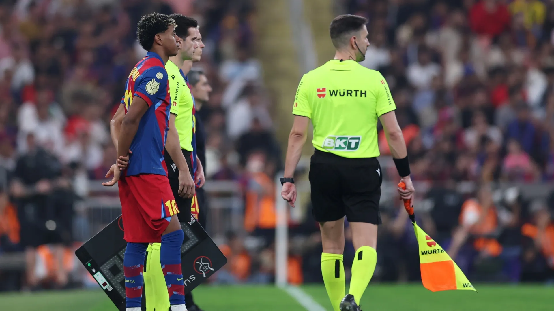 Lamine Yamal of FC Barcelona looks on from the touchline as he prepares to be substituted on.