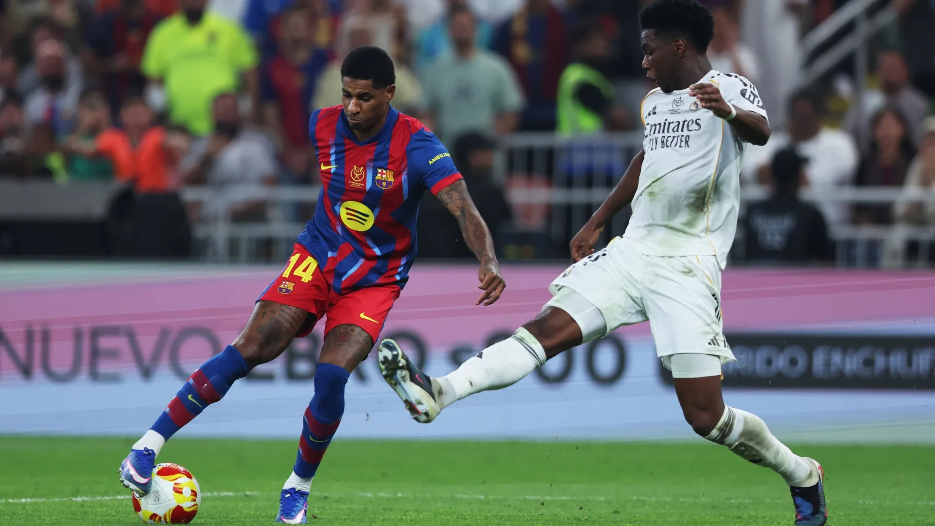 Marcus Rashford of FC Barcelona is challenged by Aurelien Tchouameni of Real Madrid.
