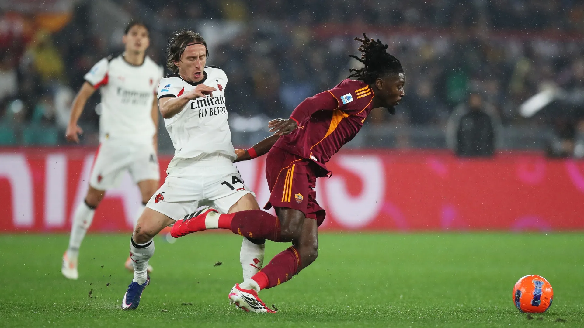 Manu Kone of AS Roma is challenged by Luka Modric of AC Milan.