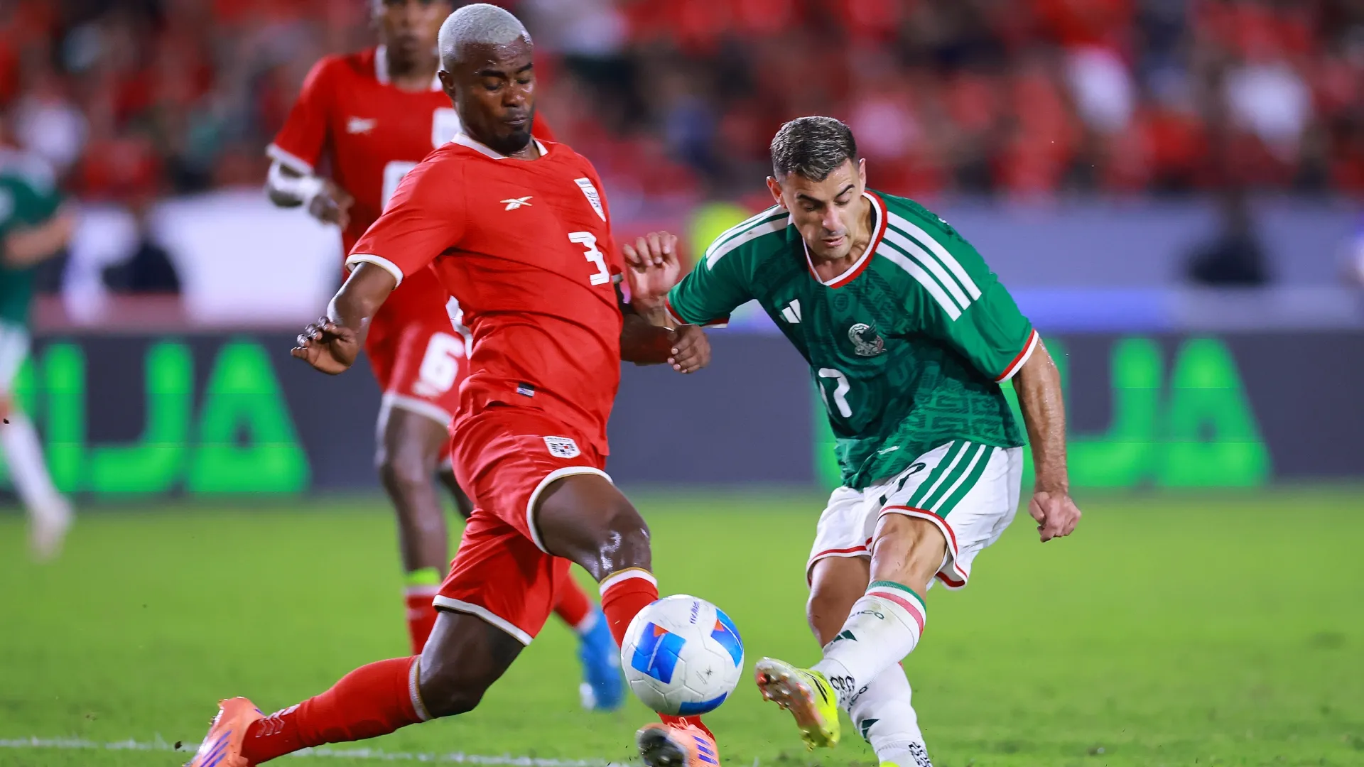 Richard Peralta of Panama battles for possession with German Berterame of Mexico.