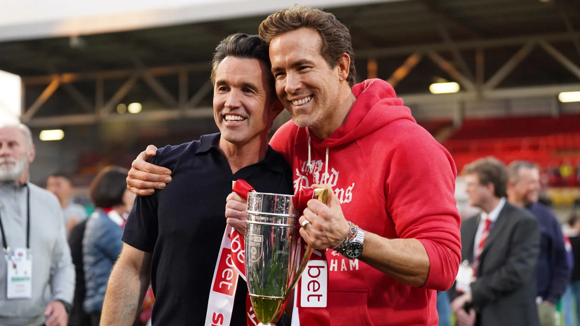 Rob McElhenney and Ryan Reynolds, co-owners of Wrexham AFC, pose for a photo with the EFL League One trophy.