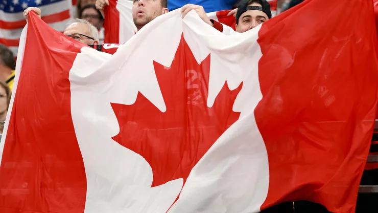 Fans of Team Canada hols up flag
