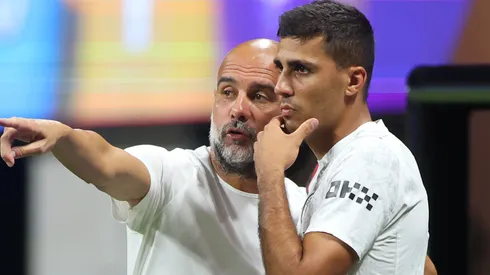 Pep Guardiola, Head Coach of Manchester City, gives Rodri #16 instructions.