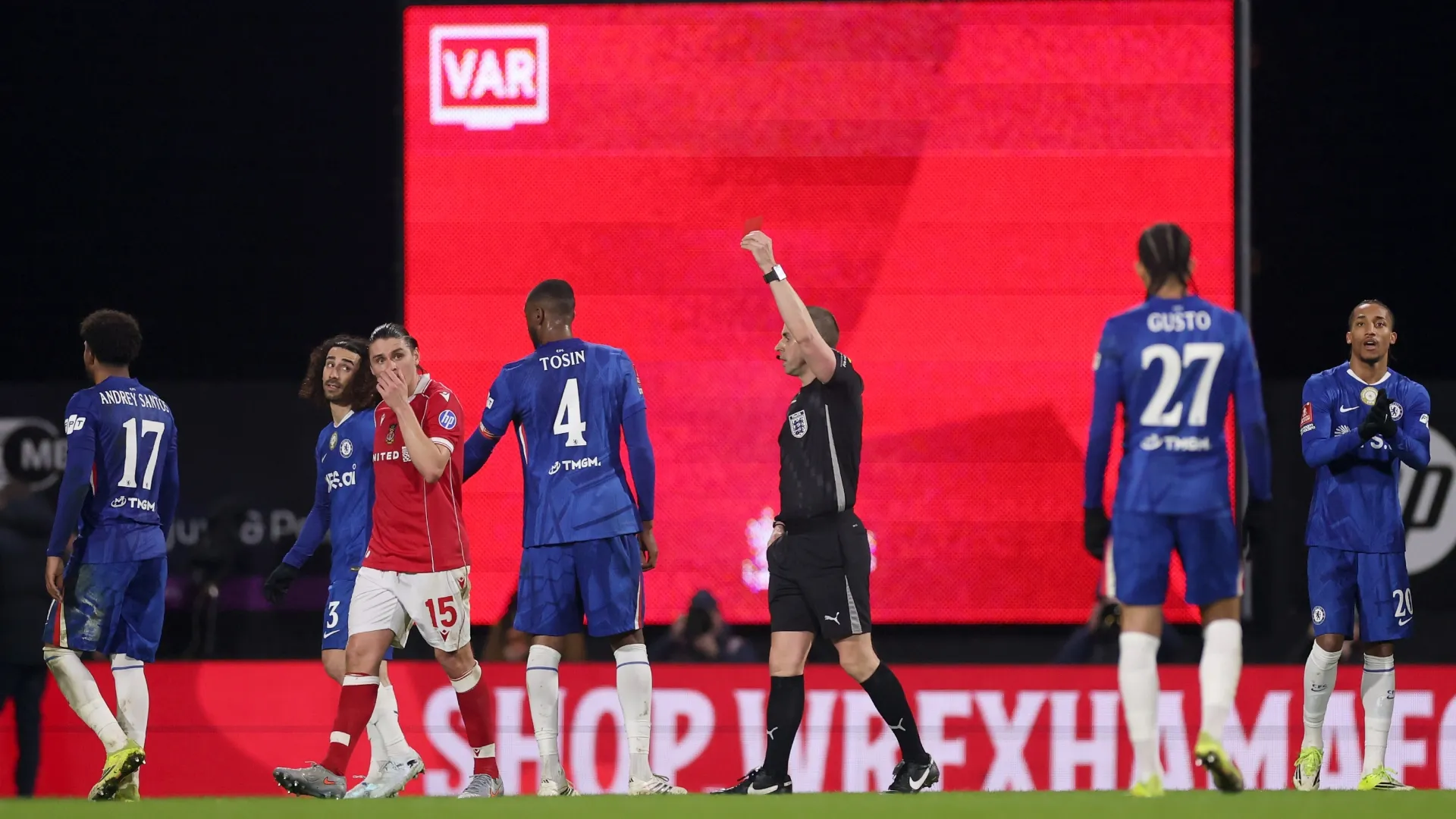 Referee Peter Bankes shows a red card to George Dobson of Wrexham.