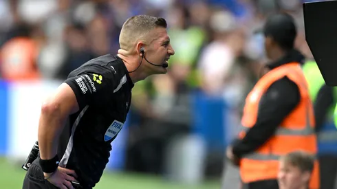 Referee Robert Jones checks the VAR screen during a Premier League match.