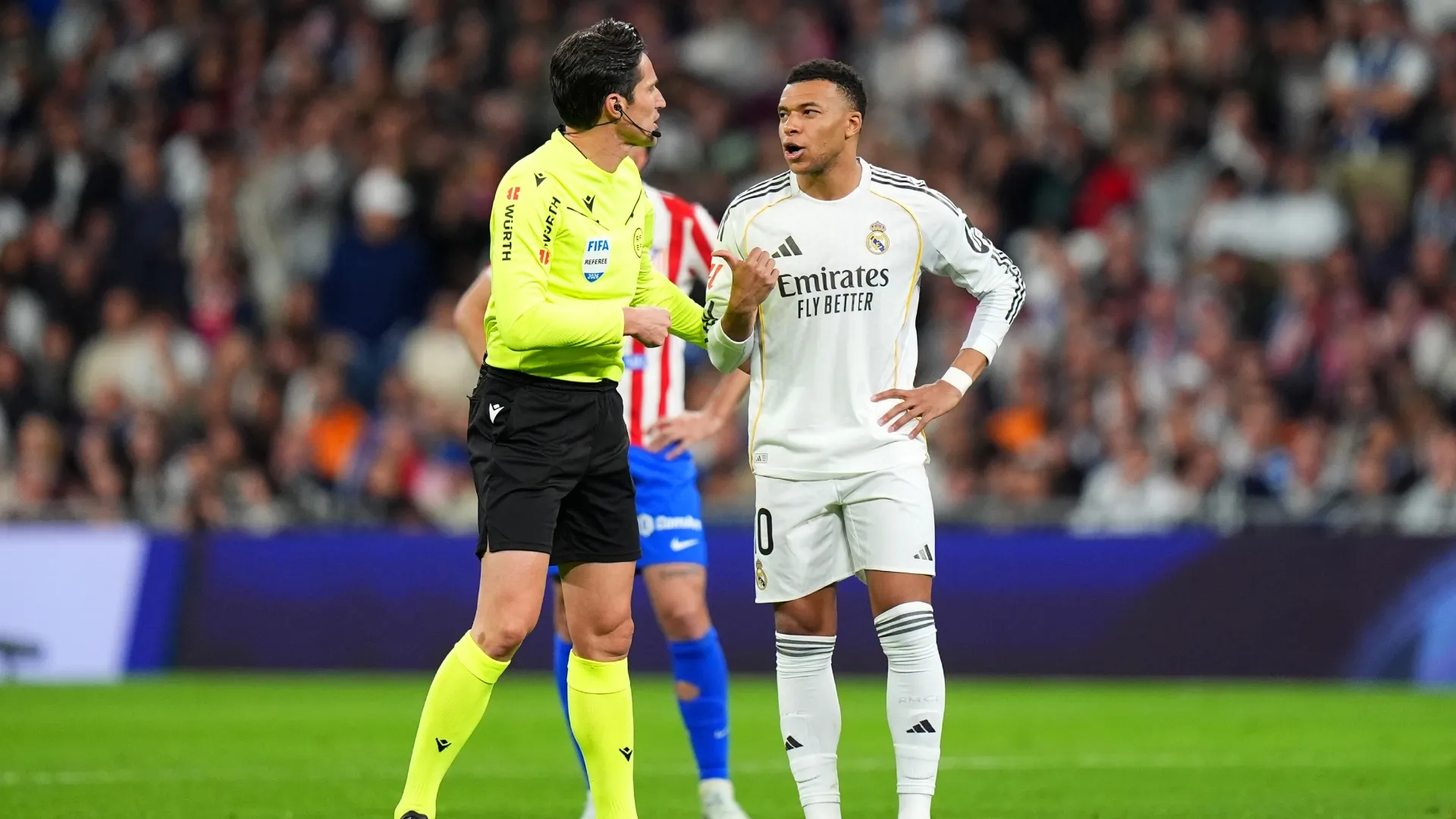 Referee Jose Munuera speaks with Kylian Mbappe of Real Madrid.