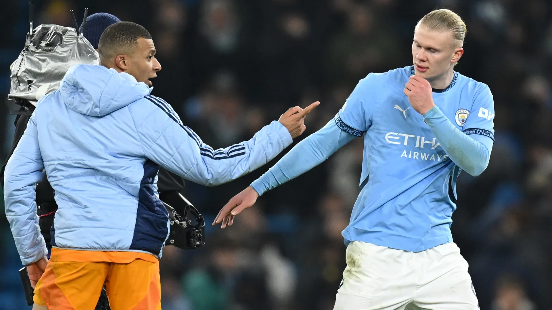 Kylian Mbappe of Real Madrid speaks with Erling Haaland of Manchester City.