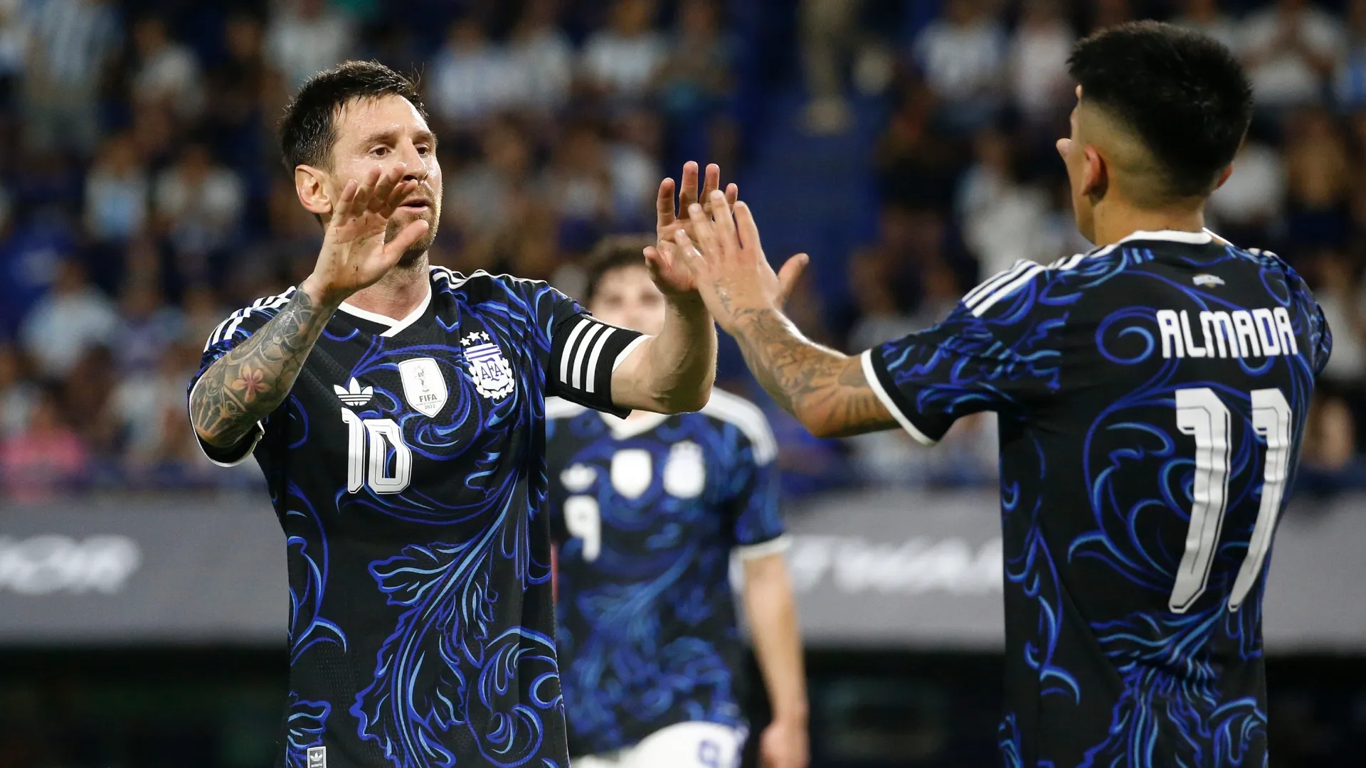 Lionel Messi of Argentina greets Thiago Almada during the international friendly match against Zambia.